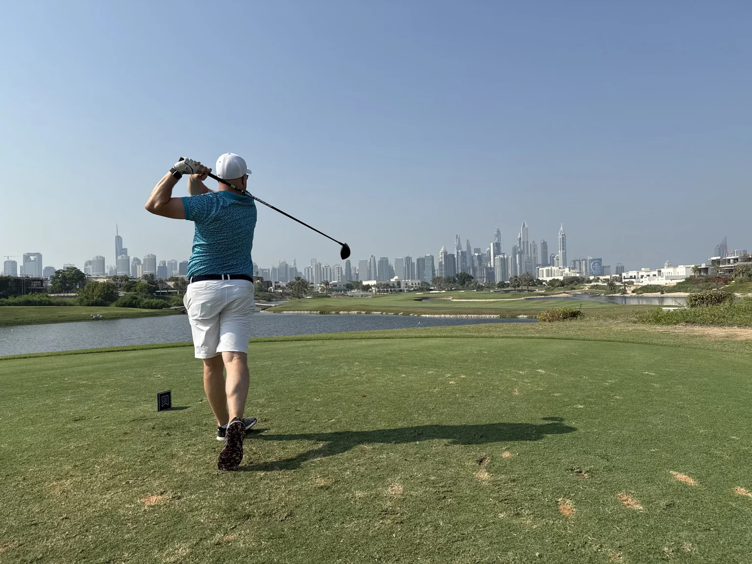 Sven Puckelwaldt beim Abschlag vor der Skyline von Dubai